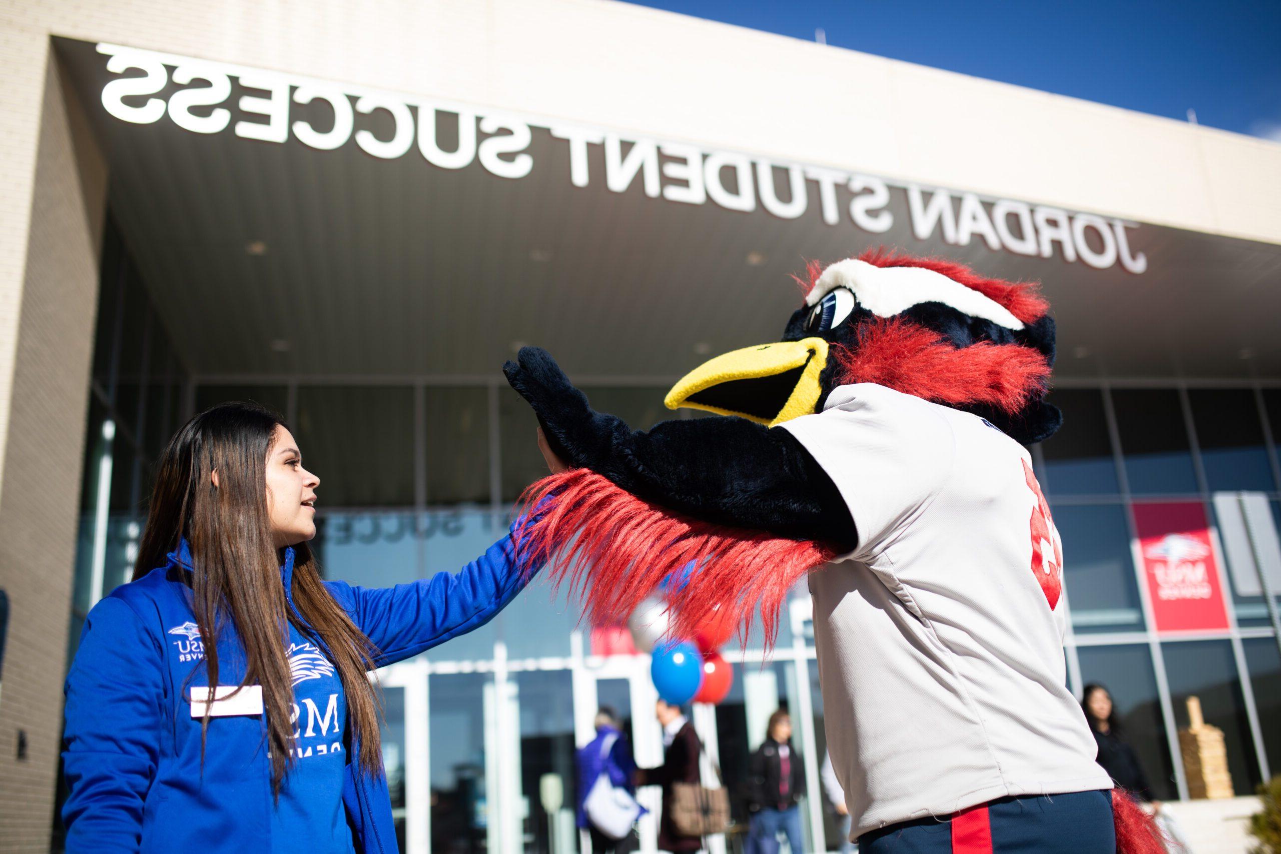 Rowdy high fives a Crew in Blue team member